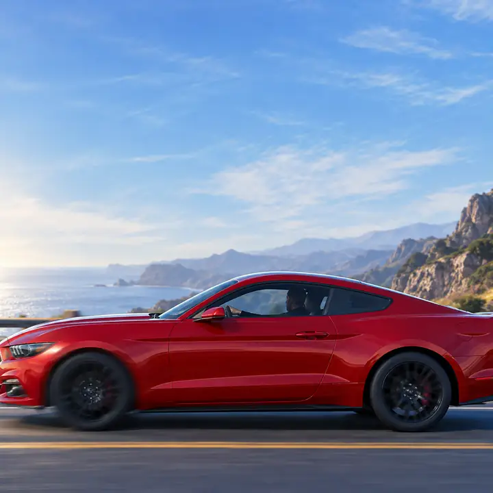 Rotes Auto, von der Seite vor einem blassblauen Himmel fotografiert